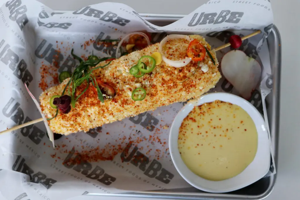 Elote a.k.a Mexican street corn dressed with mayonnaise, cotija cheese and Tajin pepper.  (Photo by Paula Murphy)