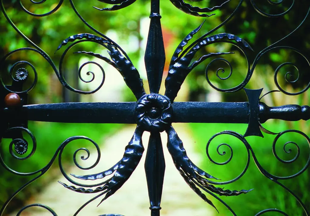 This wrought iron gate in historic downtown Charleston features a sword emblem at its center. 