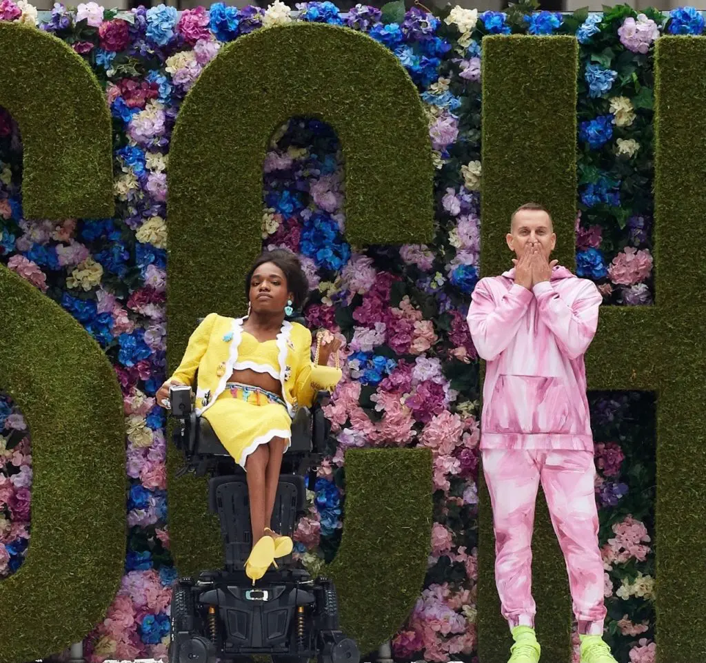 Jeremy Scott, right, and paraplegic model in yellow suit say hello to the audience at the end of the runway show. (Photo courtesy of Moschino)