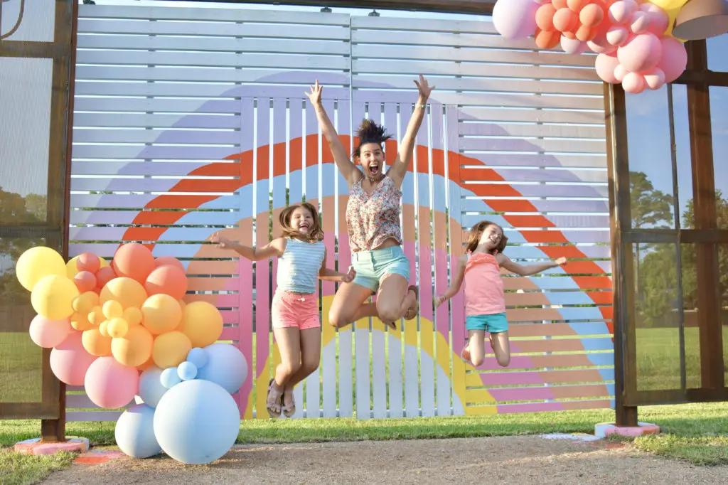 Mila, Anita, and Caroline Ticak are among the many neighbors excited by the Instagram possibilities of the latest Sugar & Cloth Color Wall at The Common, a reinvigorated shopping center on Pinemont. (Photo by Alex Montoya)