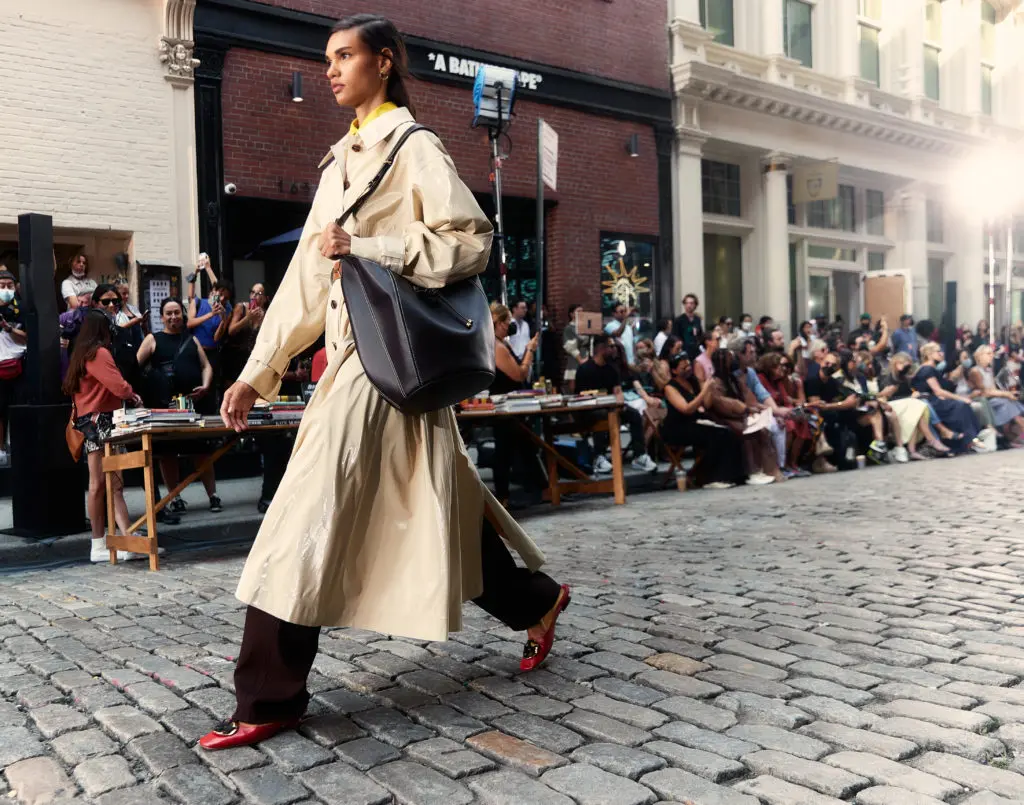 Tory Burch coated-cotton reversible trench, cotton poplin shirt, stretch faille pant, Hobo bag, Medallion mule. Photo courtesy of Tory Burch)