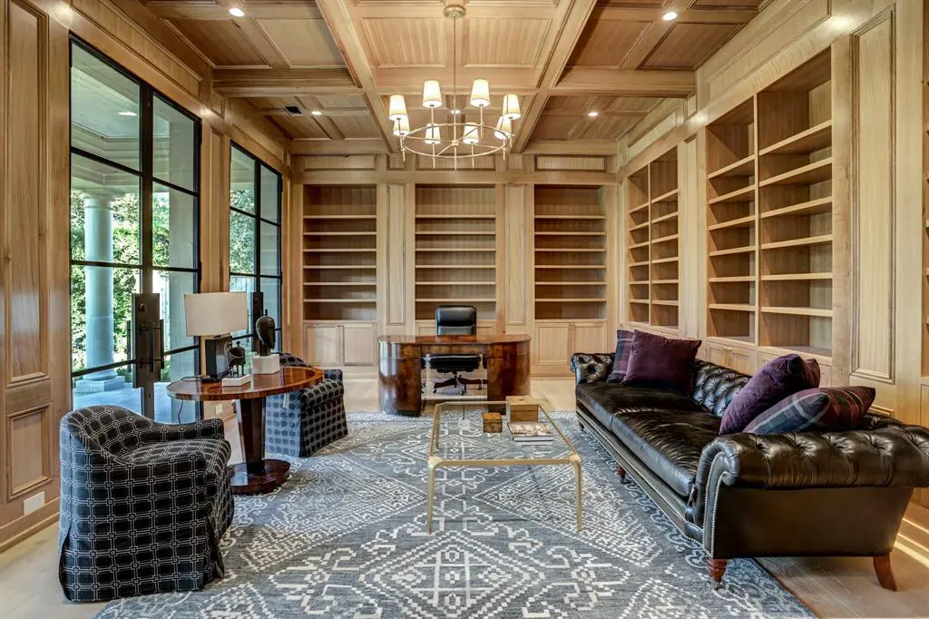 The study at 3001 Inwood with floor to ceiling white oak block paneling, box beamed ceiling, built in bookcases and cabinet storage, three sets of 10' steel and glass double doors to a covered terrace.