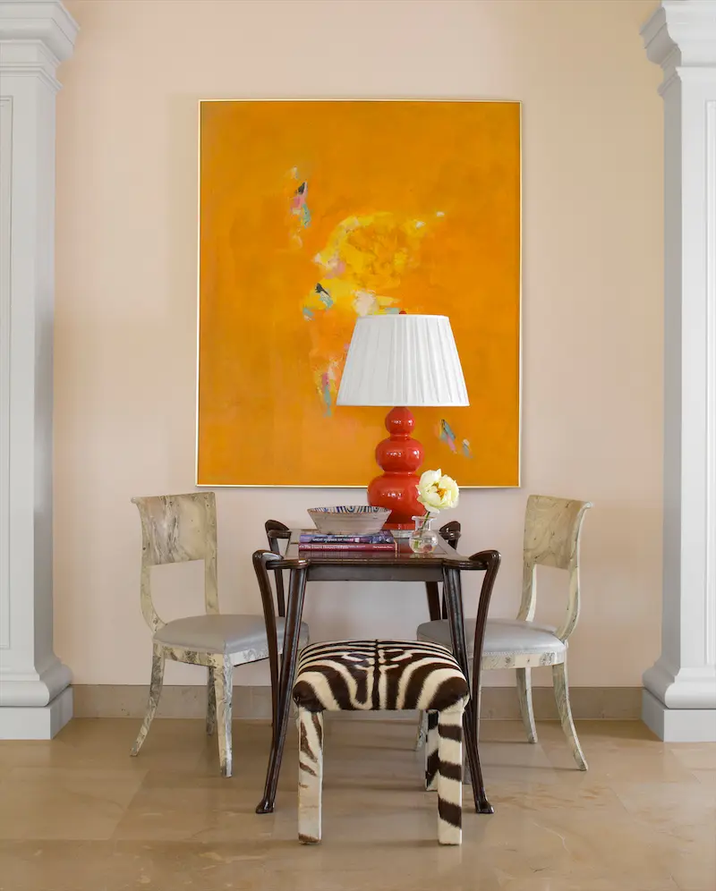 Marbleized chairs, a vintage zebra-hide bench, and a red gourd lamp set off an unusual antique backgammon table. (Photo: Emily Minton Redfield)