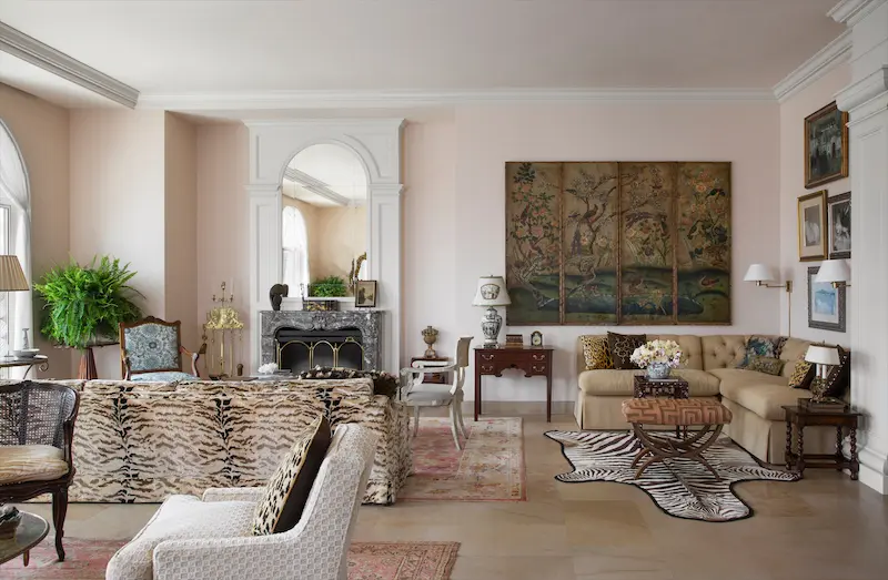In the living room, a nine-foot sofa is upholstered in Italian silk velvet tiger stripe. The marble fireplace was in the homeowner's previous house, and Minton designed a wood arch with Italian glass to go above it. Walls and ceiling are painted in Benjamin Moore's Old Country. (Photo: Emily Minton Redfield)
