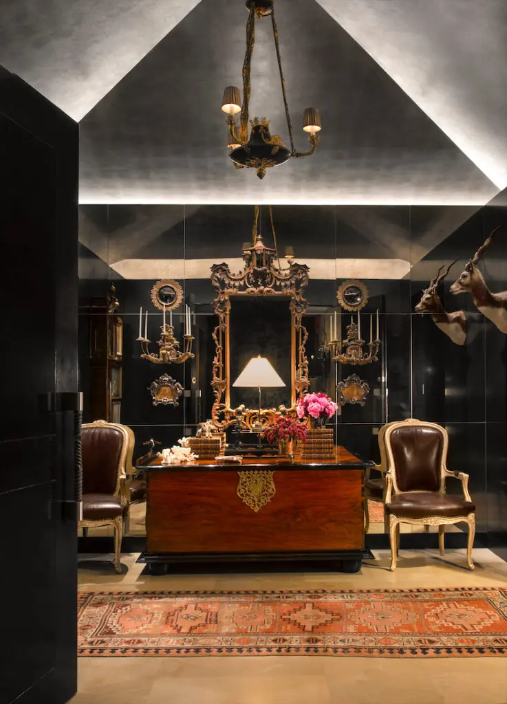 In the entryway, walls are paneled in antiqued mirror, which Minton had custom-made in Italy. The ceiling is silver leaf. The antique chest belonged to the homeowner's mother. (Photo: Emily Minton Redfield)