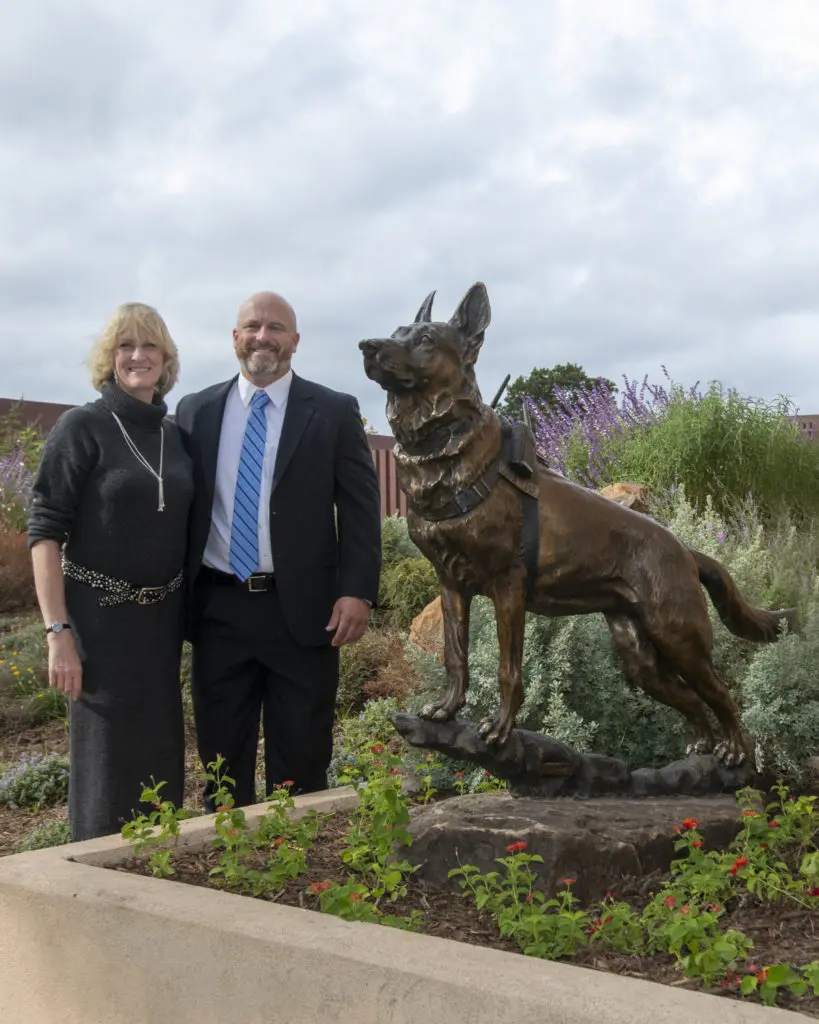 Handler Chris Willingham poses with Lucca K458 bronze in the Alice Walton Cowgirl Park alongside artist Jocelyn Russell