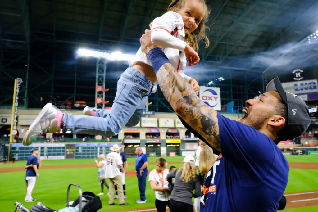 Carlos Correa lifted little Anaiah Maldonado up high in the sweetest Astros celebration yet last October. (Photo by F. Carter Smith)