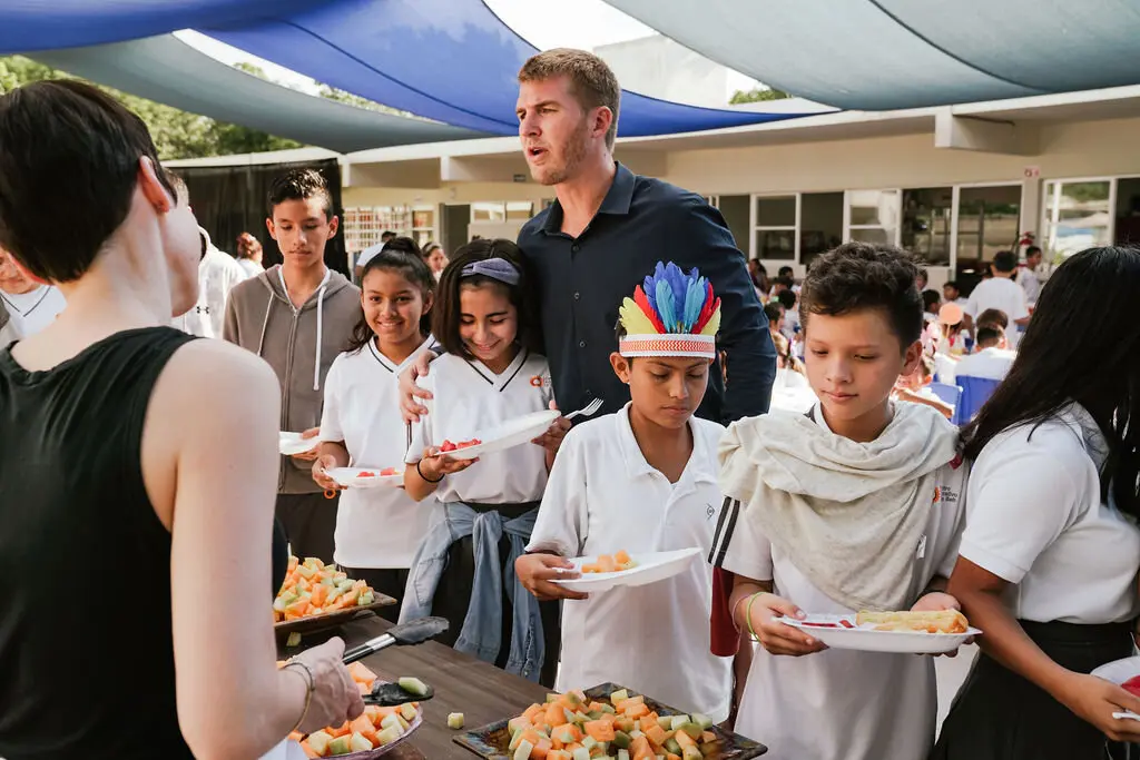 Daniel Scott, Regional Vice President and Managing Director of Rosewood Mayakoba with students of K'iin Beh School during the annual Thanksgiving breakfast. 