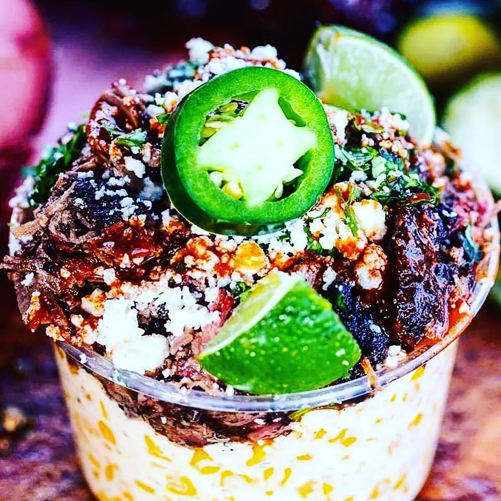 The Brisket Elote at Panther City BBQ. Prime Brisket layered on top of house blend cream corn, topped with queso fresco, cilantro, hot sauce, and garnished with a jalapeño and lime.