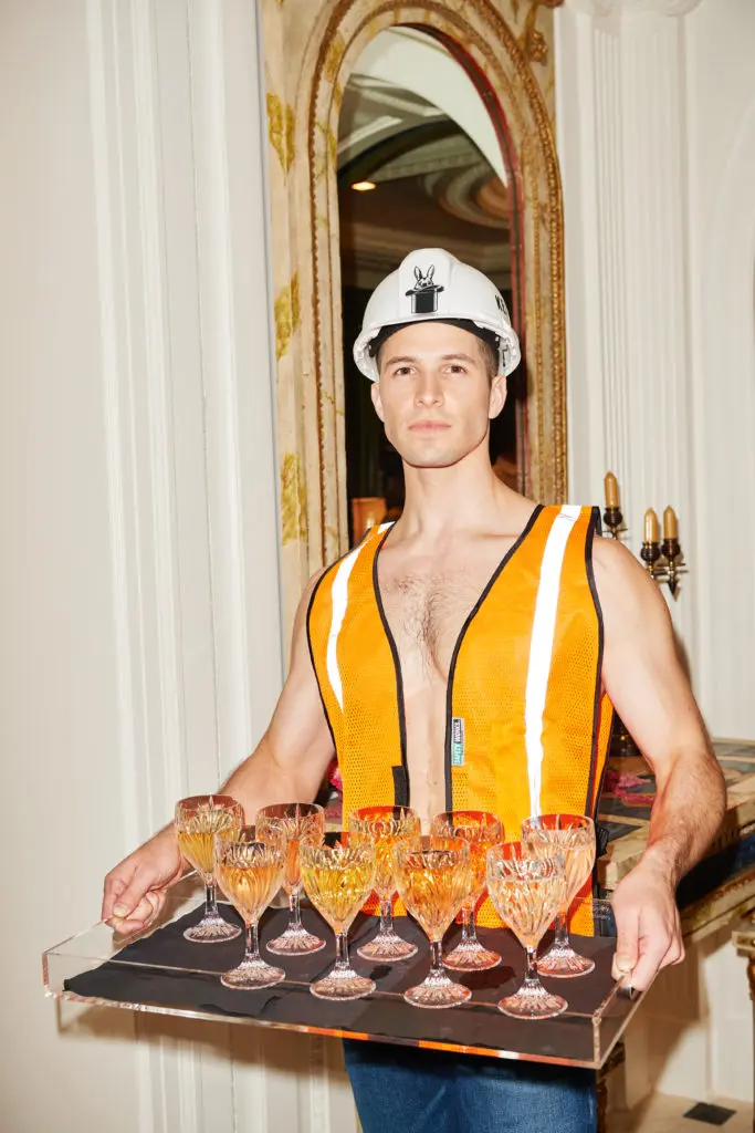 A shirtless model citizen (David Friedrich) in a hard hat serving up cocktails. (Photo by Jonathan Zizzo)