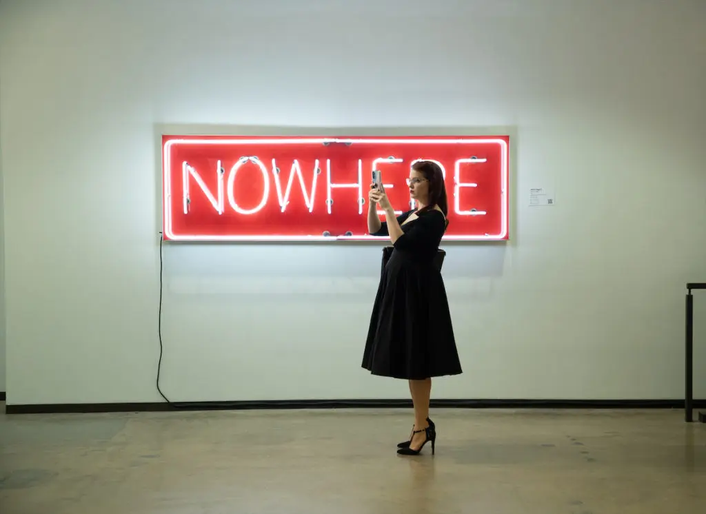 A visitor in front of a neon artwork by Alicia Eggert. Dallas Art Fair Preview, 2021. (Photo by Exploredinary)