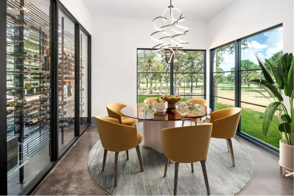 Formal dining backed by its 500 bottle wine storage. Photos courtesy of Zach Spross, for Douglas Elliman.