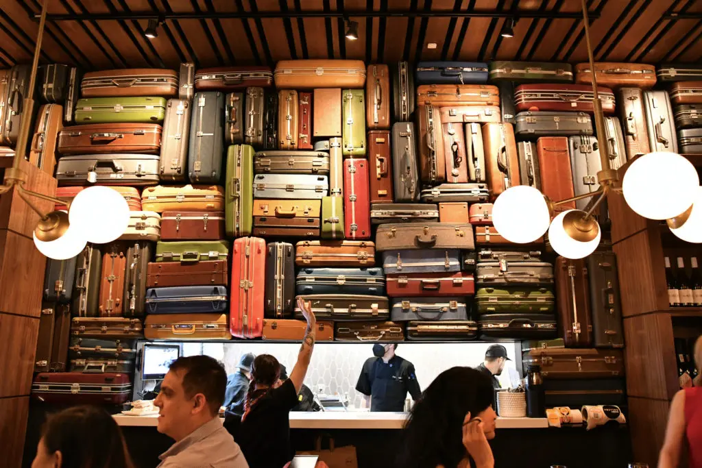 The artistic assembly of vintage suitcases at Postino in Uptown Park (Photo by Alex Montoya)