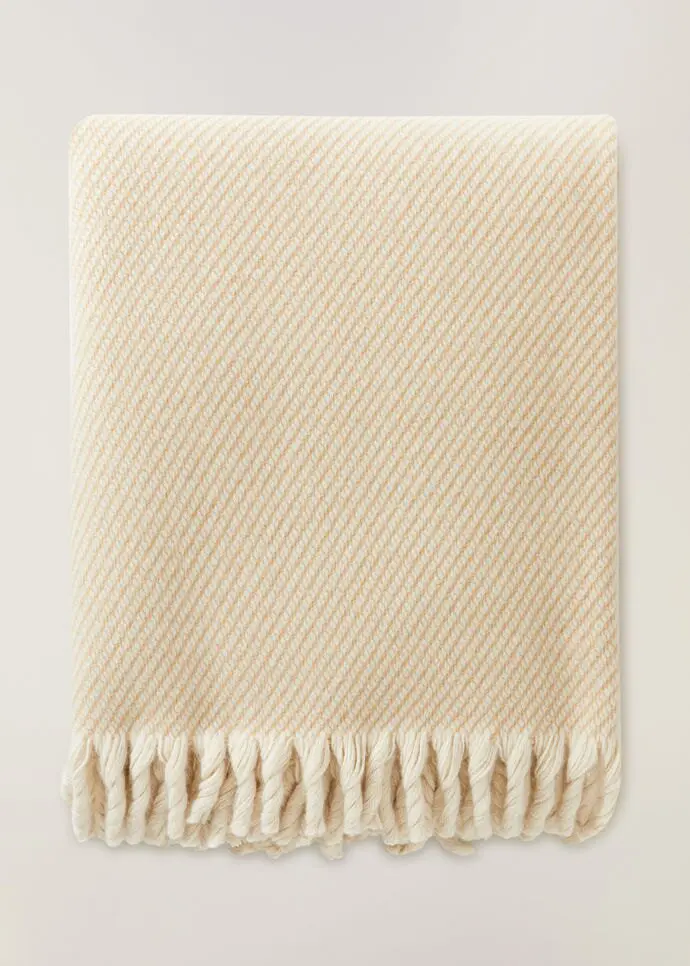 Nothing is cozier than snuggling up with this Loro Piana cream blanket this holiday.