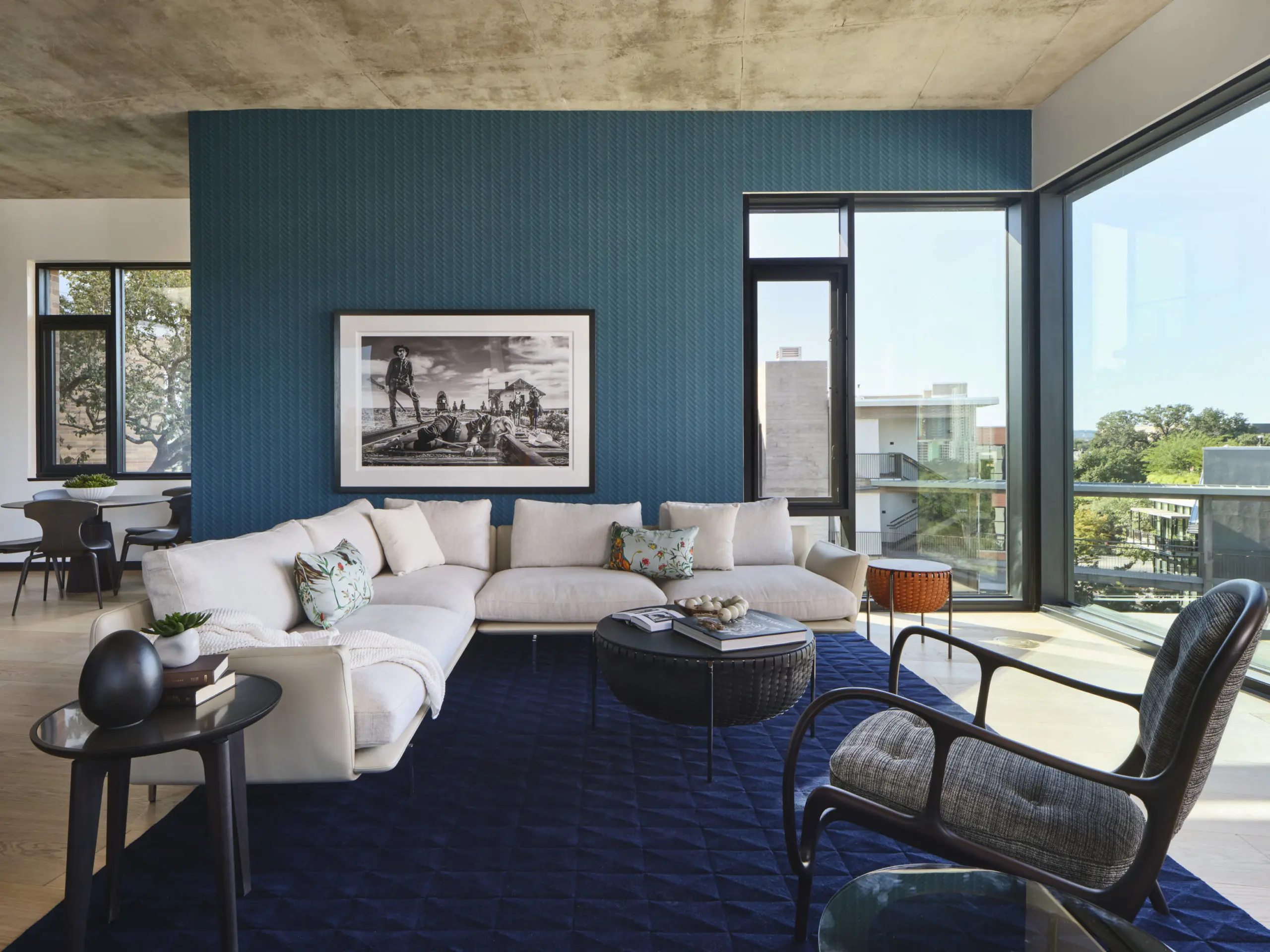 A bold statement living room wall was used to accentuate stunning views by using Wall & Deco wall coverings with David Yarrow “310 to Yuma” art and an exclusive handcrafted Kymo Atelier 3D cut rug .  Poltrona Frau sofa and storage tables, Giorgetti end table, Ceccotti  armchair, Malabar console and Rimadesio glass end table complete the space. (Photography by Andrea Calo)