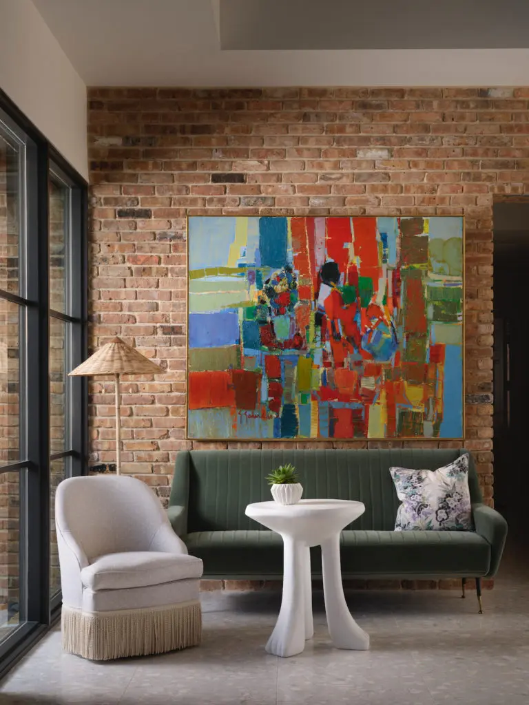 A sitting area in the entry includes a 1960s Italian sofa from Obsolete. Plaster table, Dickinson by John Dickinson at Sutherland. Chair from Nicky Kehoe. Arteriors floor lamp. The painting belonged to Christy Berry’s mother. (Photo by Lisa Petrole)