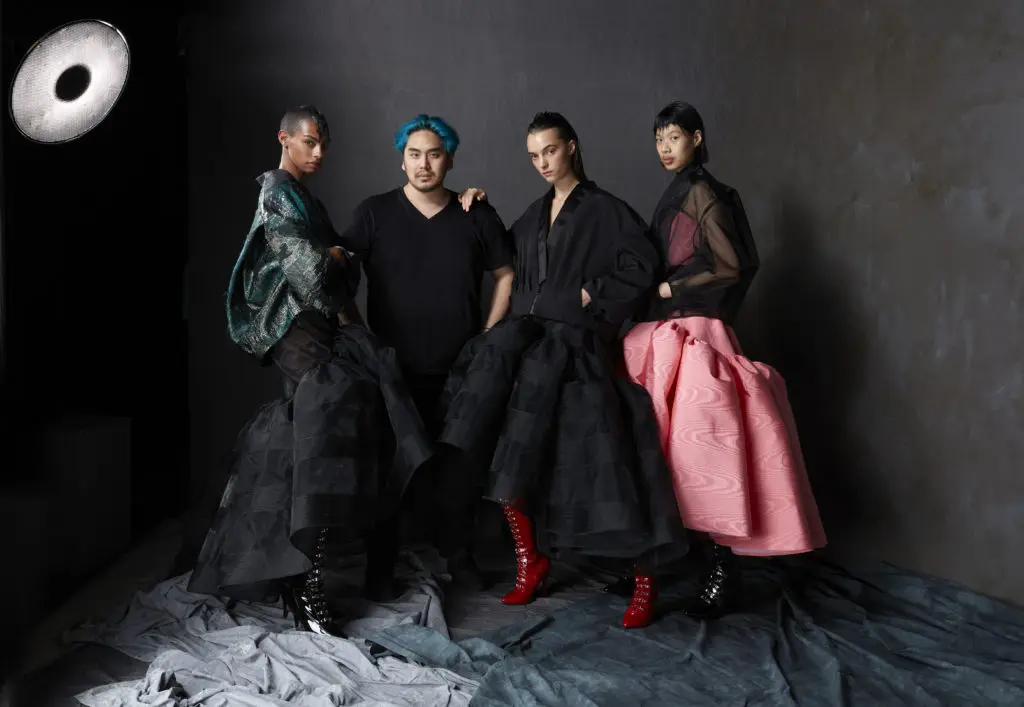 Bach Mai poses with models in looks from his debut collection. (Photo by Dimitri Hyacinthe)