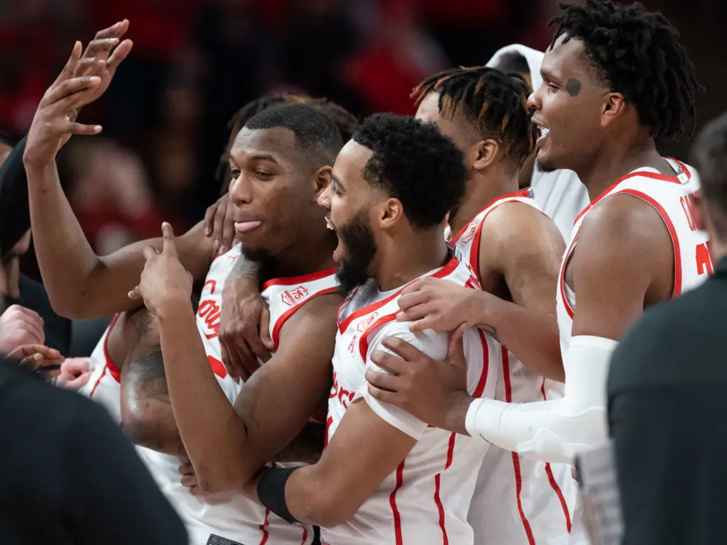 The UH players gathered around Fabian White Jr. to celebrate him becoming the winningest player in the Fertitta Center's short history. (Photo by F. Carter Smith)