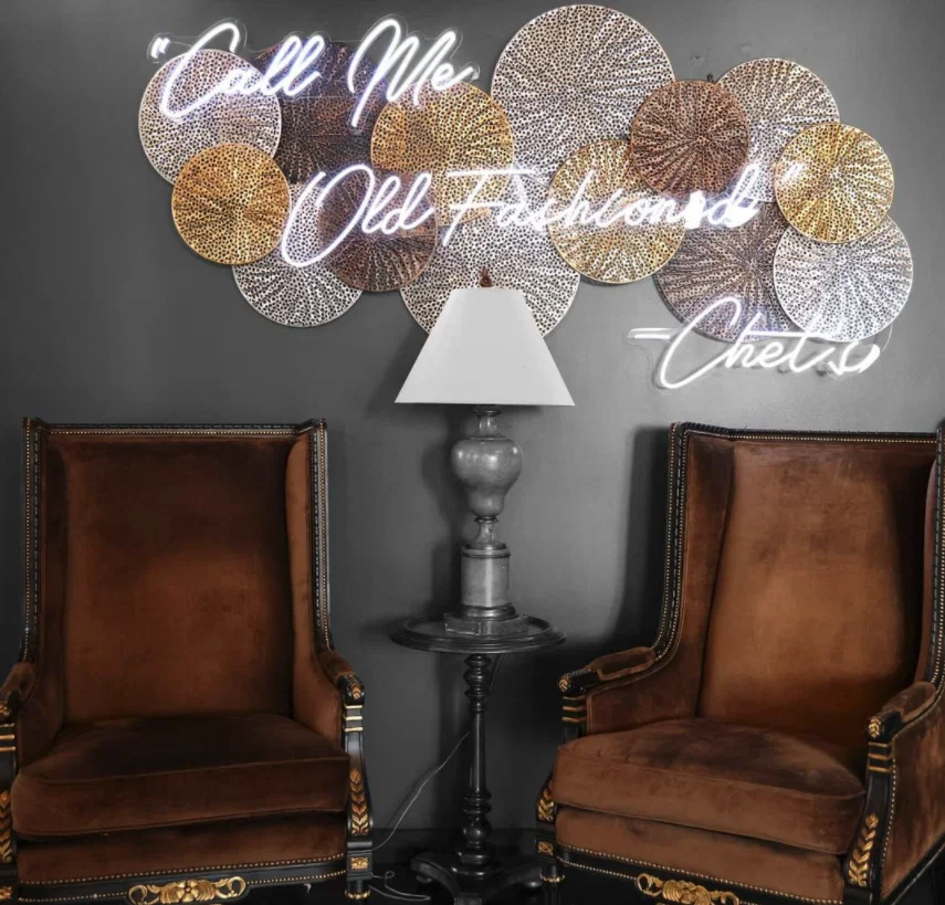 Chet's boasts upscale library vibes with crystal chandeliers, big chairs, and a neon sign that reads "Call Me Old Fashioned - Chet's." (Courtesy)