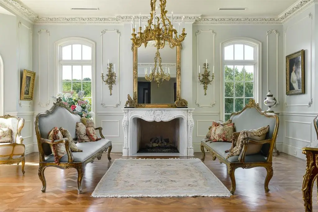 Baroque details include the parquet flooring, moldings and carved marble fireplace.