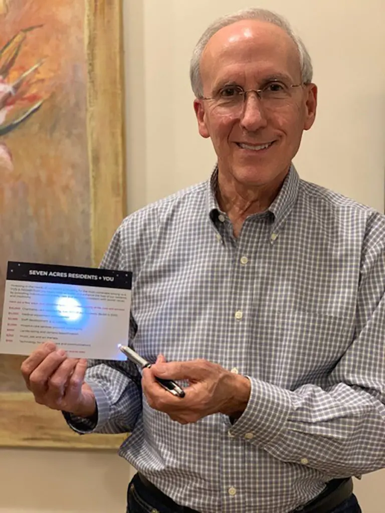 Seven Acres Board of Trustees treasurer Lee Straus with his donor card during the virtual gala.