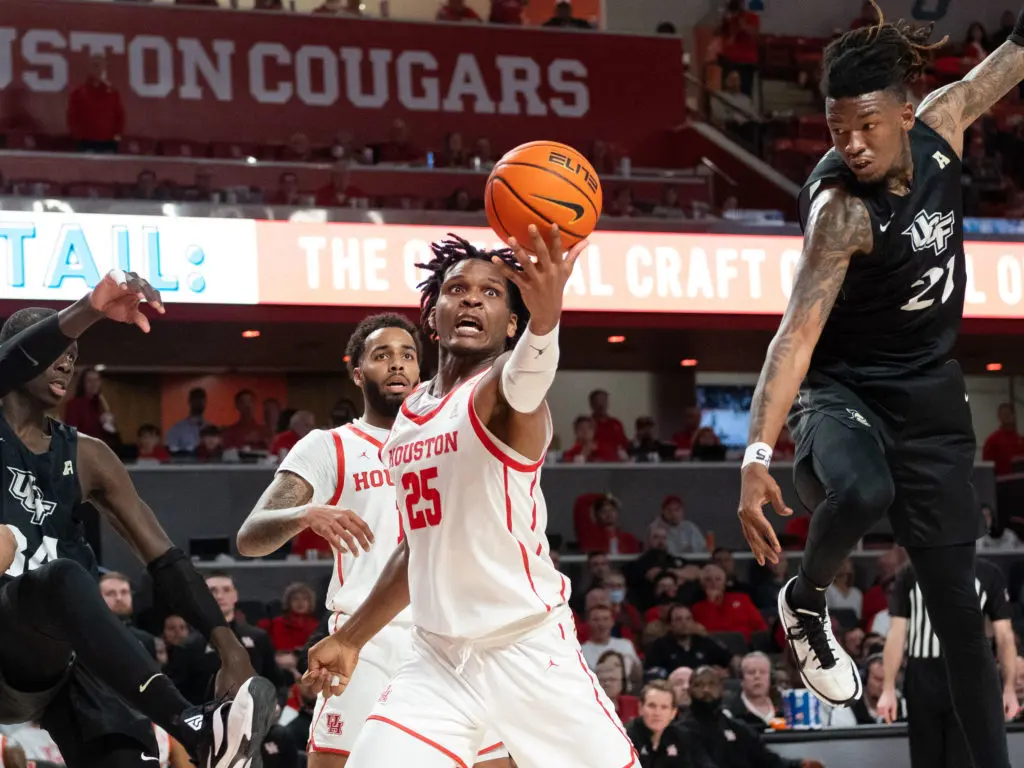 UH center Josh Carlton does not let a crowd stop him from scoring. (Photo by F. Carter Smith)