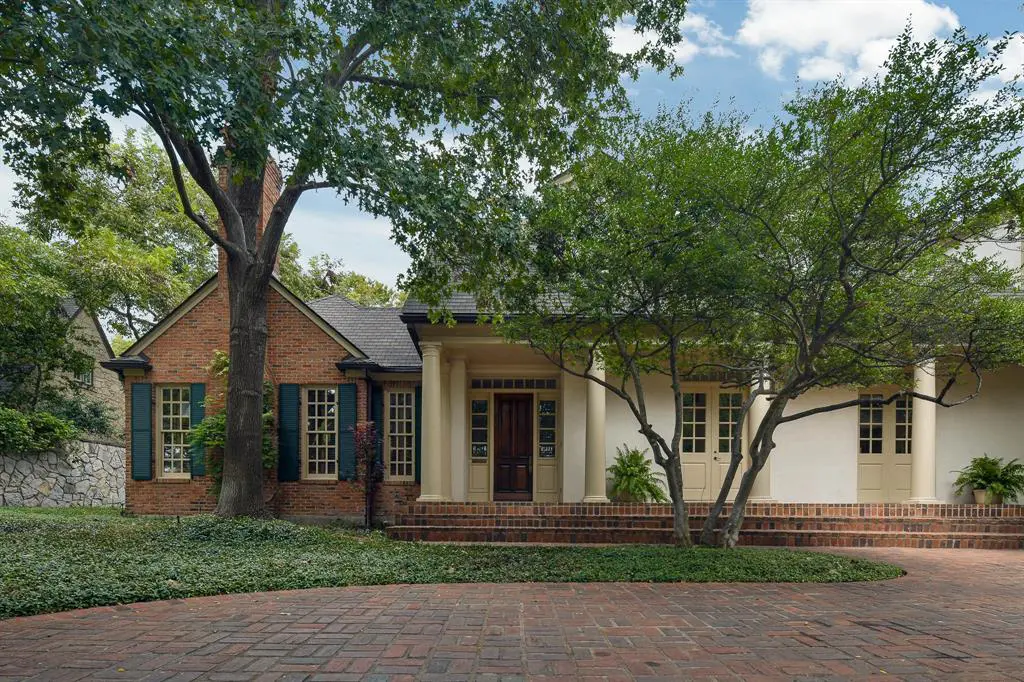 An elegant front patio, handsome dormers, and red brick with a lovely patina define 3616 Lovers Lane. 