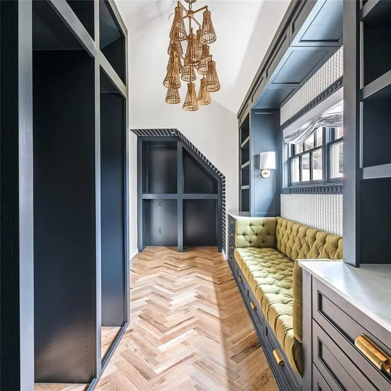 Much of the work from Dallas-based Burkle Creative remains in the primary closet, including bespoke built-ins, the rattan chandelier, and detailed trim work by Casci Plaster. (Photo by Costa Christ Media)