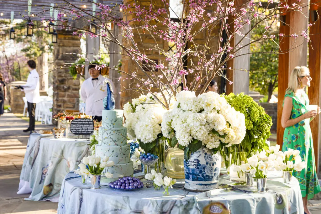 Event Chair Kim Darden greets guests alongside gorgeous floral display at An Evening in the Garden. (Photo by Ellman Photography)