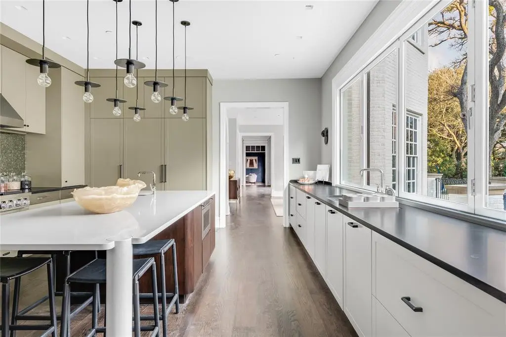 Studio 6F’s fern green cabinetry remains in the kitchen, as well as the custom Cambria quartz island. (Photo by Costa Christ Media)
