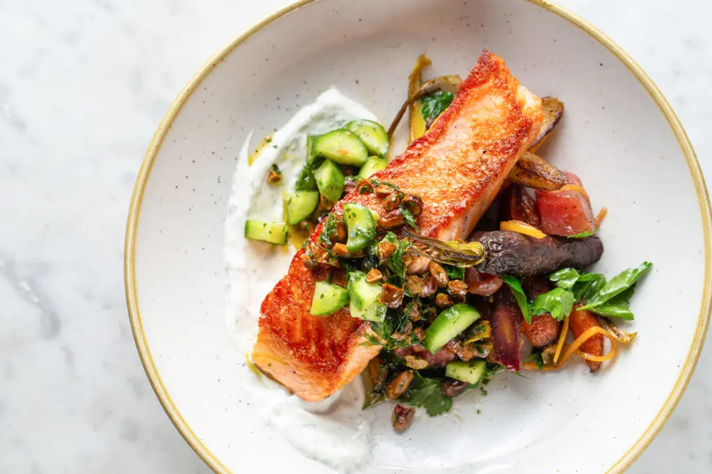 Salmon with preserved lemons, dill lime labneh, cucumber, and pistachio is new to the Brasserie 19 menu. (Photo by Andrew Hemmingway)