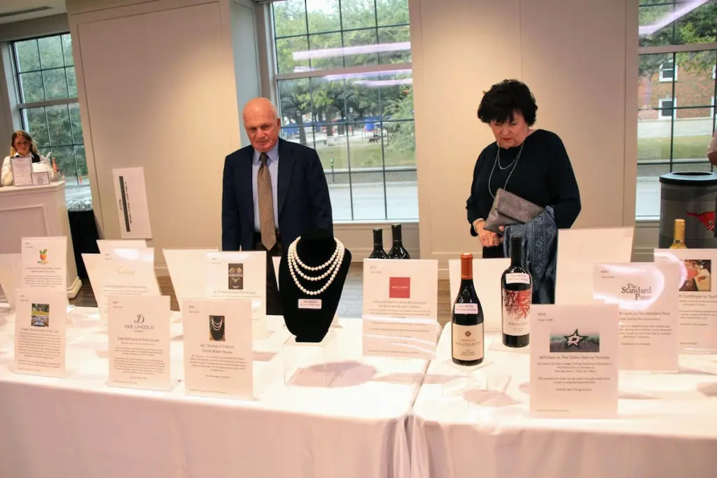 J.W. and Ann Brown browsing silent auction items, featuring pearls from private jeweler Carter Malouf. 