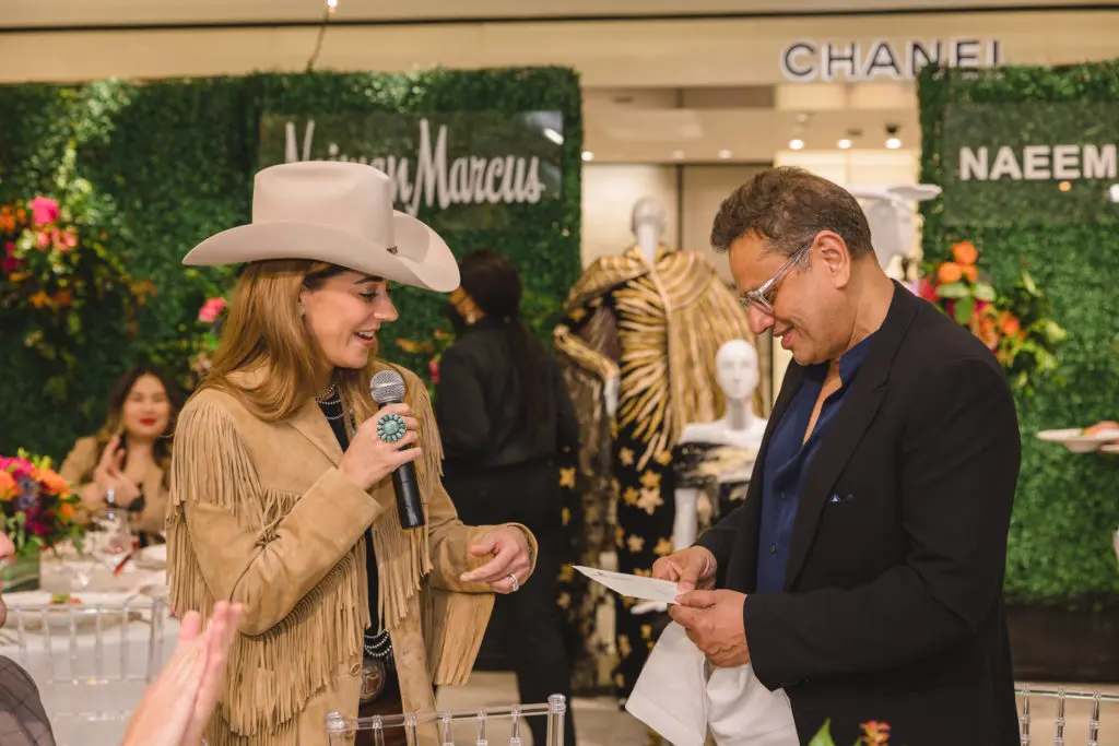 Kristina Somerville presents Naeem Khan with front row tickets to the 2022 Houston Livestock Show and Rodeo.  (Photo by Johnny Than)