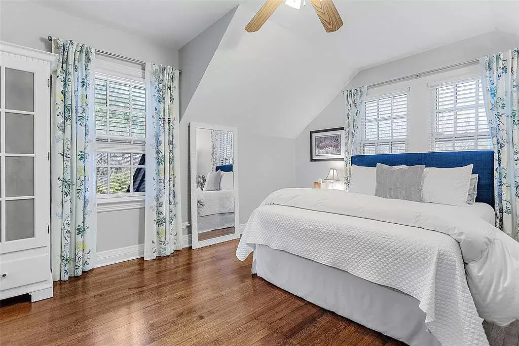 A secondary bedroom wiht hardwood floors. 