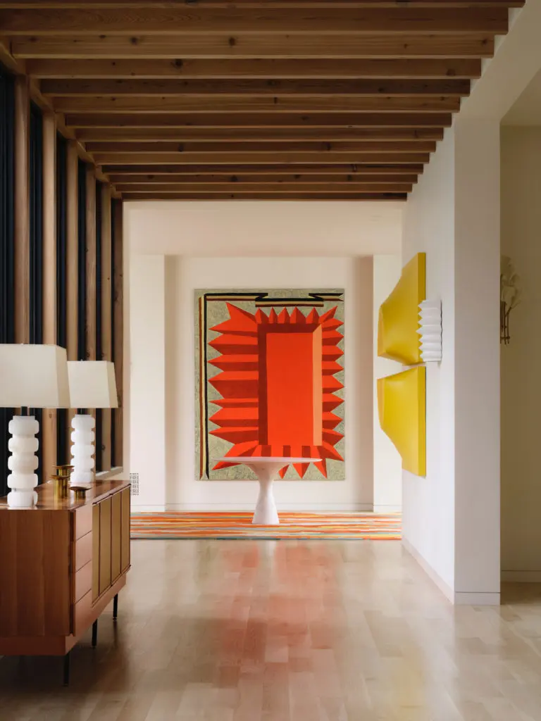 Cedar beams add visual warmth to the main gallery. A painting by Matt Kleberg from Barry Whistler Gallery dominates, with Samantha McCurdy's stretched-spandex wall sculptures, at right. Marble table from Smink. Credenza from Paris Underground, Aspen. (Photo by Lisa Petrole)