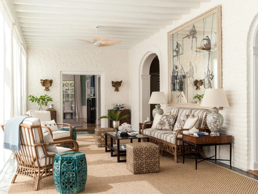 Veranda in a Palm Beach house with ottomans covered in handwoven mats from Borneo. The eglomise mirror is original to the house.