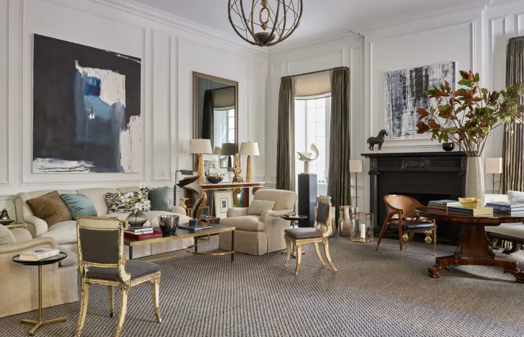 For a room in Holiday House, a show house benefiting breast cancer
research, there are layers of history with designs from different periods
and countries. The console and side chairs are English Regency, contrasting with the contemporary French bronze globe chandelier. Contemporary artwork
includes Curtis Jer sculpture on the coffee table, an Emilia Dubicki painting
above the sofa, and a painting by Victor-Raul Garcia over the fireplace.