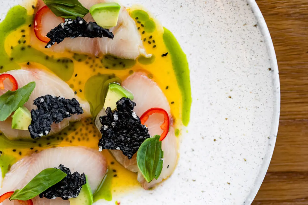 Marmo's Hamachi Crudo appetizer is bathed in passion-fruit spiked ponzu sauce with a ring of fresh red chile. (Photo by Kirsten Gilliam)
