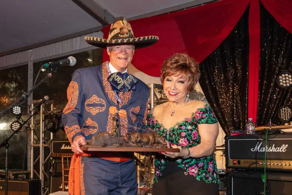 Bryan Museum founder J.P. Bryan presents Trini Mendenhall with the Buck 'n Ball Award at the museum gala in Galveston (Photo by Michael Mckenny) 