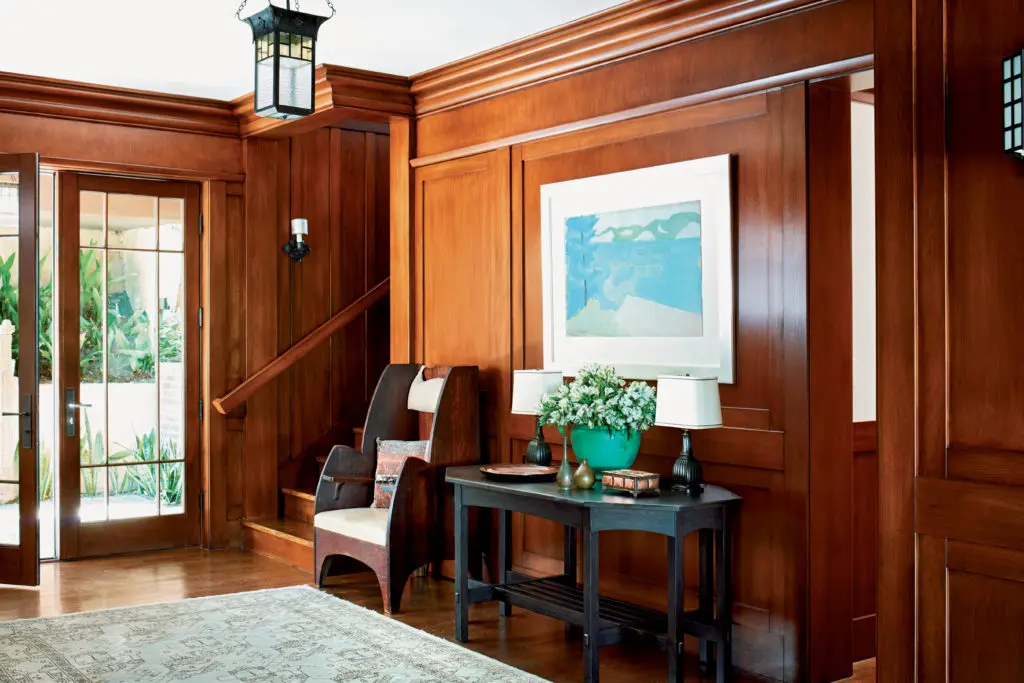 A Milton Avery watercolor hangs on one of the entry’s paneled oak
walls. The Arts and Crafts chair is by the Charles P. Limbert Furniture Company, the vintage lantern is French, and the bronze lamps are by Danish metalworker Just Andersen. On the entry console a lacquered Japanese plate and Edo-period bronze vases are grouped with an early twentieth-century vase from the Grueby Faience Company.