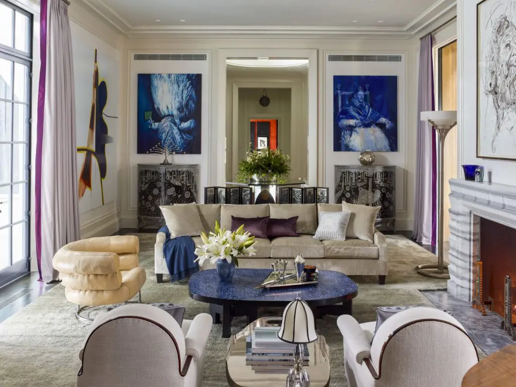 Flanking the door to the gallery, Glenn Brown’s "The Great Queen Spider" (2009) and Yan Pei Ming’s  "Innocent X Outremer" (2015) hang above a pair of black, silver, and mother- of-pearl demilune cabinets from Galerie Mougin that display a nickeled-brass candelabrum by Bruno Paul (ca. 1901) and a silver sculpture by Kevin Francis Gray (ca. 2015). The seating area includes an Eileen Gray Bibendum chair ,and a pair of Leleiere armchairs by Émile- Jacques Ruhlmann (ca. 1925) that flanks a Maria Pergay coffee table (ca. 1958), on which rests a Josef Hoffmann lamp (1923). 