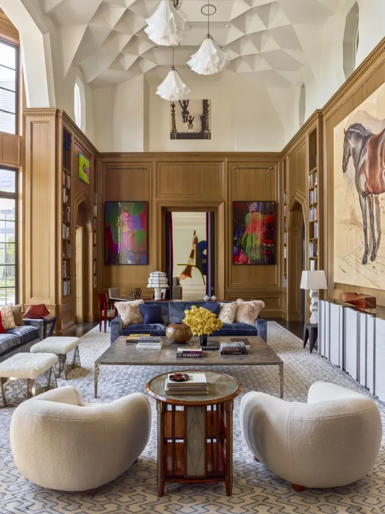 Flanking the door into the living room are two Cibachrome prints by Mike Kelley, "John Glenn" and "Bigfoot" (2001). In the niche above is Mamma Andersson’s "Hangman" (2014). In the foreground, a rosewood, shagreen, and ebony table- bibliothèque tournante (ca. 1920) by Clément Rousseau is flanked by a pair of Royère Polar Bear chairs fabricated by August Studios. 
