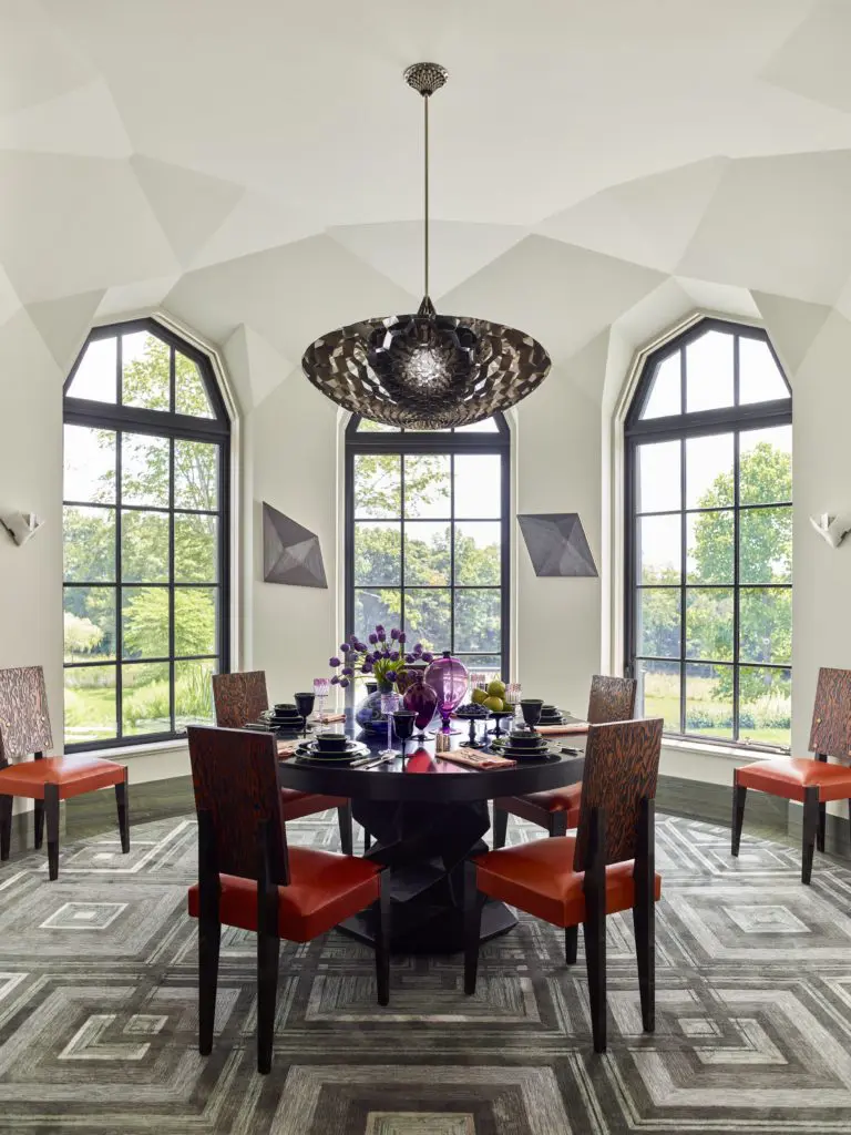 The custom silk-and-wool rug was made by V’Soske. The nailhead-studded, Oregon pine and beech chairs were designed by André Sornay (ca. 1936). The table is set with a dinner service by Steuben Glass Works (ca. 1925), violet wine glasses by Otto Prutscher (1912), a Leune vase (ca. 1925), and two Vittorio Zecchin Veronese glass vases designed for Venini/Cappelin (1925). 