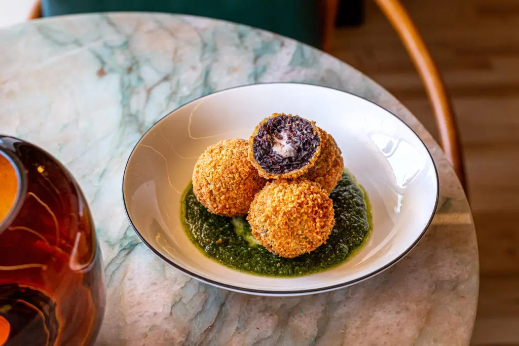 Indulge in warm black rice arancini filled with oozing cheese at the intimate 1,000 square foot new wine bar dubbed Lees Den. (Photo by Jenn Duncan)