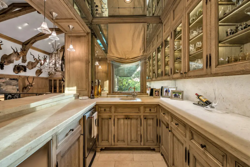 Custom cabinetry line the wet bar, which is perfectly located for entertaining.