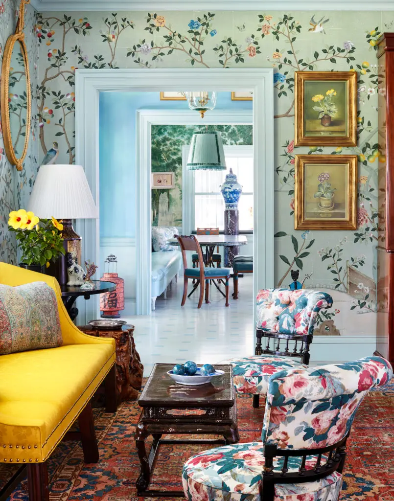 A charming seating area in the dining room includes an antique sofa. The pair of slipper chairs, upholstered in Jasper fabric, once belonged to Robert Denning and Vincent Fourcade. Walls are papered in de Gournay. (Photo by Trevor Tondro and Otto )