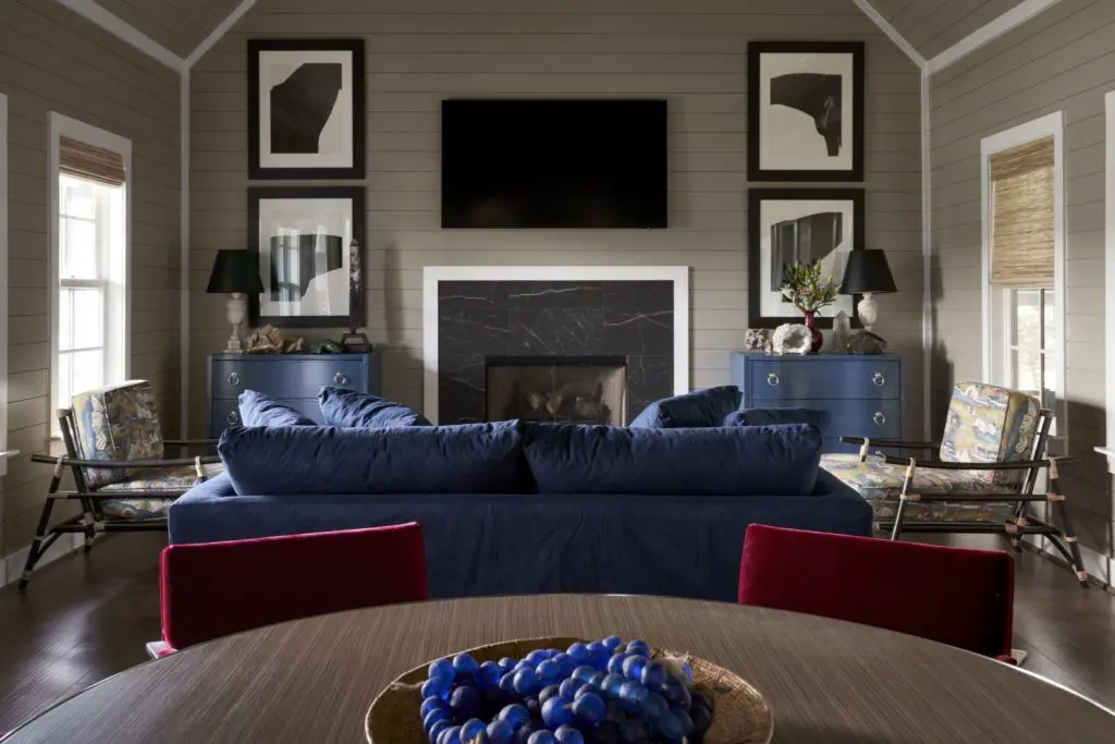 In one of the great rooms, Knoll chairs in red mohair started the inspiration for this bungalow's modern mix, which includes a pair of Article rattan chairs and a linen slipcovered sofa from Grandin Road. Blue glass balls from Paul Michael, Round Top. Abstract black and white photographs of horses by photographer Steven Klein. (Photo by Pär Bengtsson)