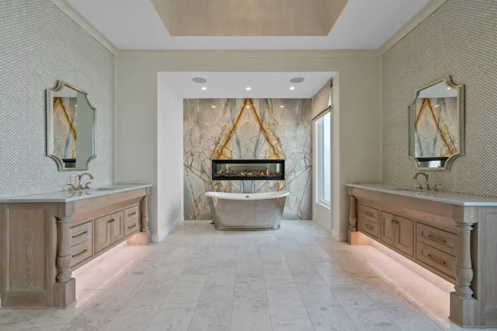 The dual sided primary bath with its inspiring see-through fireplace and soaking tub backed by stunning granite.
