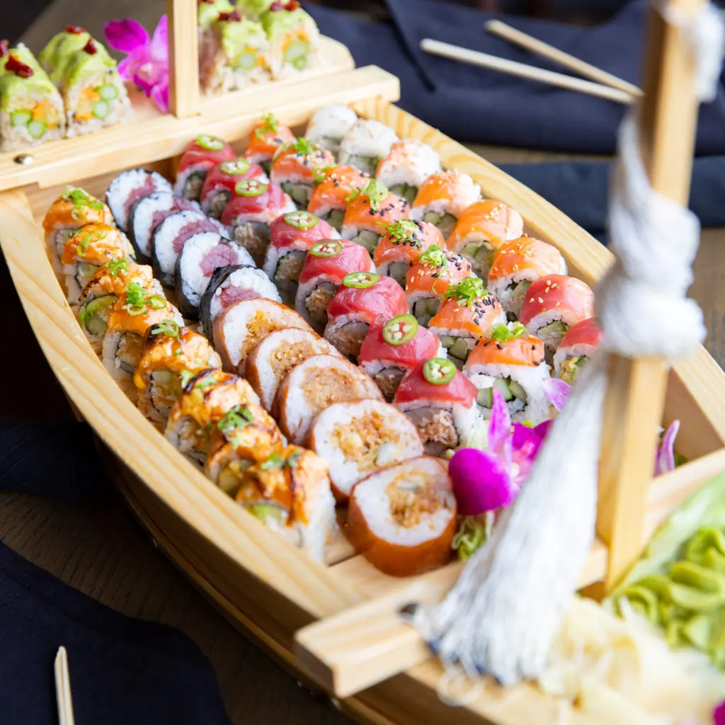 Impress your party, order several styles of sushi rolls and request they arrive tableside on this charming replica of a fishing boat. (Courtesy of Flagship Restaurant Group)