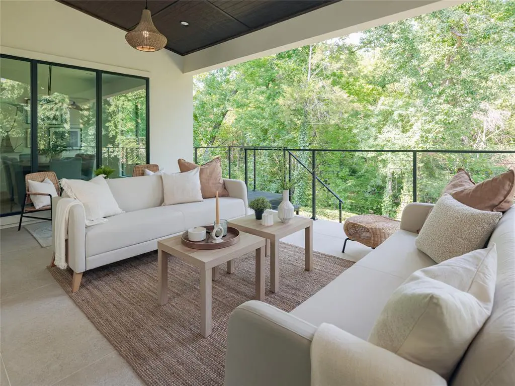 A covered porch looks out upon serene natural surroundings. 